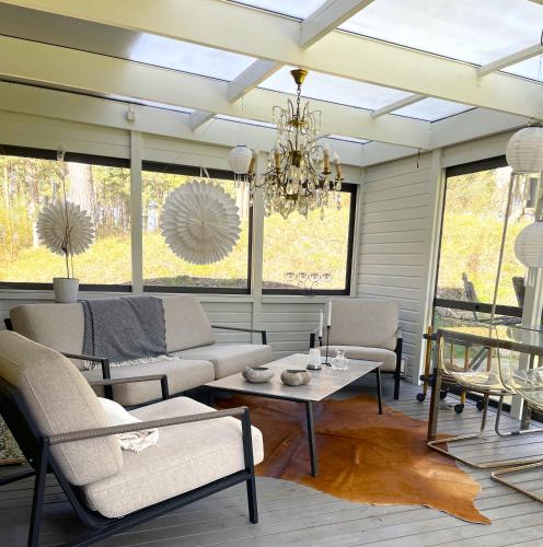 a living room with a couch and a chandelier at Villa Åhus By The Beach in Åhus