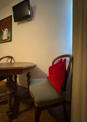 a red pillow sitting on a chair next to a table at Mainsommer in Kemmern