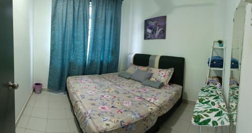 a small bedroom with a bed with blue curtains at MAM Guesthouse Kota Tinggi in Kota Tinggi