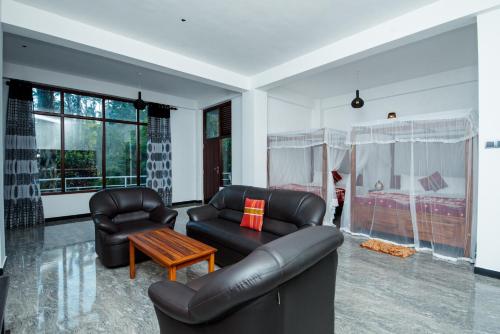 a living room with a leather couch and chairs at Adams Peak Inn in Adams Peak