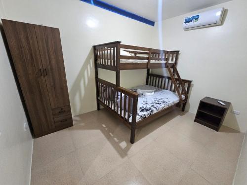 a small room with two bunk beds and a door at Mangotree Apartel & Resort in Panglao