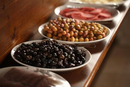 quattro ciotole di olive e pomodori su un tavolo di Turquaz Cave Hotel a Göreme