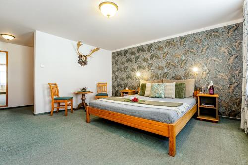 a bedroom with a bed and two chairs at Hotel Panská in Bechyně
