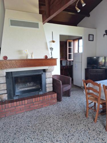 - un salon avec une cheminée, une table et des chaises dans l'établissement Charmante maison en pleine montagne basque, à Saint-Jean-Pied-de-Port