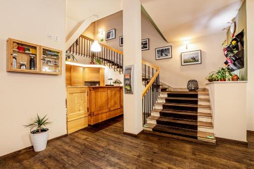 a hallway with a staircase and a kitchen with a stair case at Hotel Panská in Bechyně
