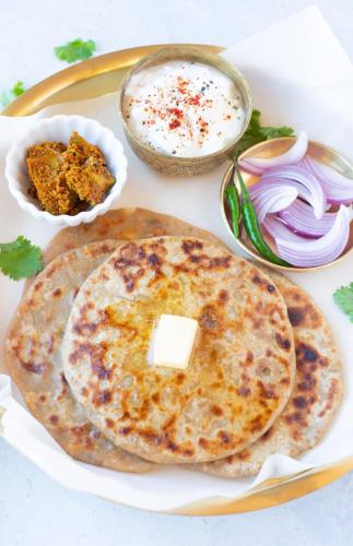 un piatto di cibo con due chapati, salsa e cipolle di Shubhra Home Stay And Restaurant a Rishikesh