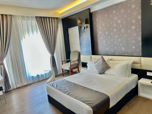 a hotel room with a bed and a chair at The Sterling Boutique Hotel Melaka in Melaka