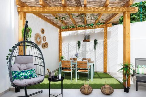 a patio with a table and chairs and a pergola at Roots Apartments in Faro