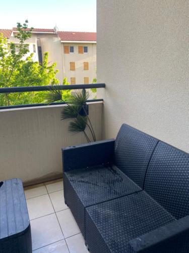 un canapé bleu assis sur un balcon avec une fenêtre dans l'établissement Appartement cosy et moderne, à Marseille