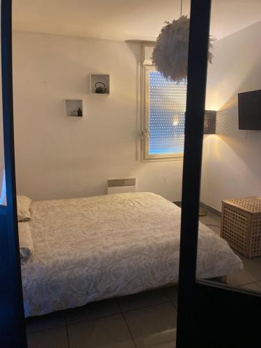 une chambre avec un lit et une fenêtre dans l'établissement Appartement cosy et moderne, à Marseille