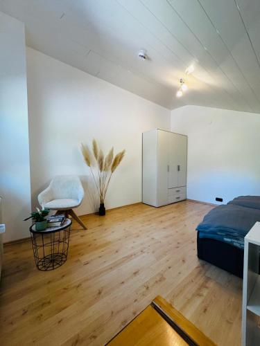 ObergünzburgにあるFerienwohnung Allgäuherzの部屋にベッドと椅子がある寝室