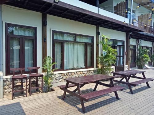 two picnic tables and benches on a wooden deck at Landmark Farmhouse in Bharatpur