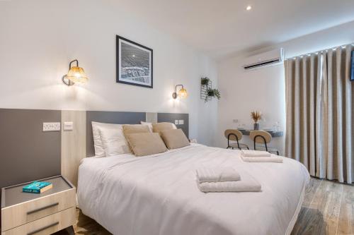 a bedroom with a large white bed and a desk at Studio apartment 4 with kitchenette at the New Casa Vittoria by SF HOMES in Cospicua