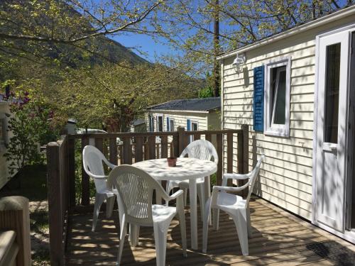 a patio with a table and chairs on a deck at Camping Calme et Nature in Castellane