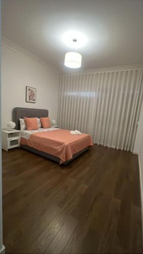 a bedroom with a bed with orange sheets on it at Odivelas Place 1 in Odivelas