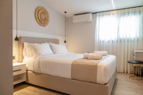 een slaapkamer met een bed met witte lakens en een raam bij Zen Apartments By The Sea in Kos-stad
