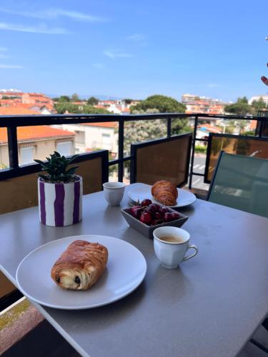 une table avec deux assiettes de nourriture et une tasse de café dans l'établissement Appartement cosy à 2 pas de la mer, idéal familles, à Canet