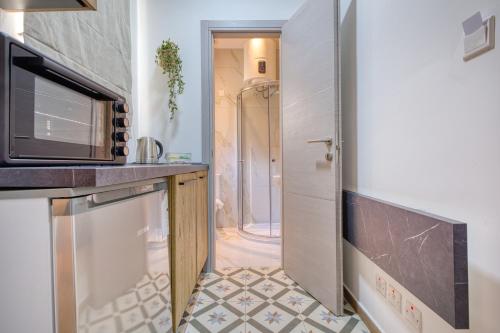 a small kitchen with a sink and a shower at Studio apartment 4 with kitchenette at the New Casa Vittoria by SF HOMES in Cospicua