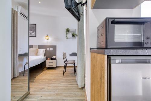 a room with a bed and a television on a counter at Studio apartment 4 with kitchenette at the New Casa Vittoria by SF HOMES in Cospicua