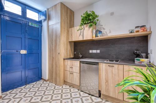 a kitchen with a blue door and wooden cabinets at Studio apartment 4 with kitchenette at the New Casa Vittoria by SF HOMES in Cospicua