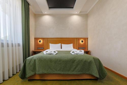 a bedroom with a bed with two towels on it at Molfar Resort Hotel & SPA Карпати in Shaian