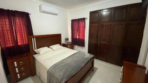 a bedroom with a bed and wooden cabinets at Pool view first floor 2 Bdrm Condo in Punta Cana