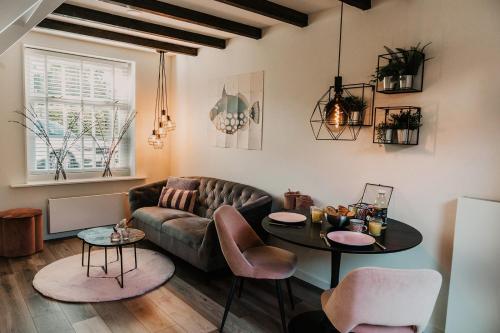a living room with a couch and a table at Vakantiehuisje Dichtbij Zee in Vlissingen
