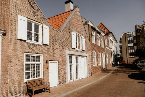 a brick building with a bench on a street at Vakantiehuisje Dichtbij Zee in Vlissingen