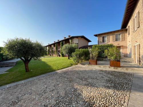 ein Innenhof eines Hauses mit Bäumen und Kies in der Unterkunft La Maison in Franciacorta in Colombaro