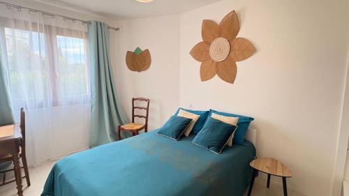 - une chambre dotée d'un lit bleu avec une fleur sur le mur dans l'établissement Belle villa rénovée, vue sur les Albères, à Argelès-sur-Mer