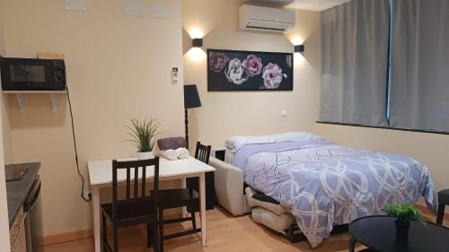 a bedroom with a bed and a desk and a table with chairs at Estudios 85 - Cerca de Madrid, Toledo y Parque Warner in Parla