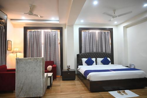 a hotel room with a bed and a chair at The Kannelite in Jamshedpur