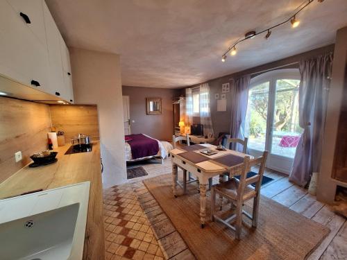 une cuisine et un salon avec une table et un lit dans l'établissement Massacan-Vue Mer, au Lavandou