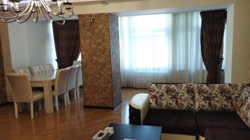 a living room with a table and a dining room at Хорошем месте находится, улица Иззет Небиев 6-22 in Baku