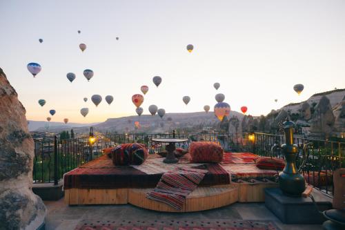 a balcony with hot air balloons in the sky at Nora Cave Hotel in Goreme