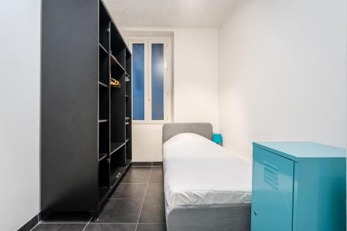 une petite chambre avec un lit et une armoire dans l'établissement Appartement lumineux au cœur de Marseille avec balcon privé, à Marseille
