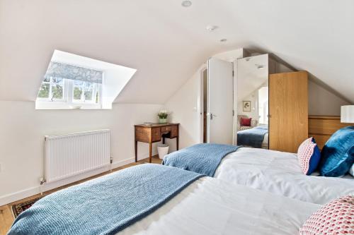 a bedroom with two beds and a window at Central Brockenhurst flat near pubs & trails in Brockenhurst