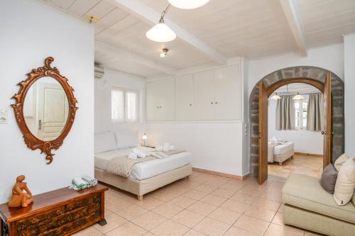 een slaapkamer met een bed, een spiegel en een bank bij Lina and Babis' Home in Adamas