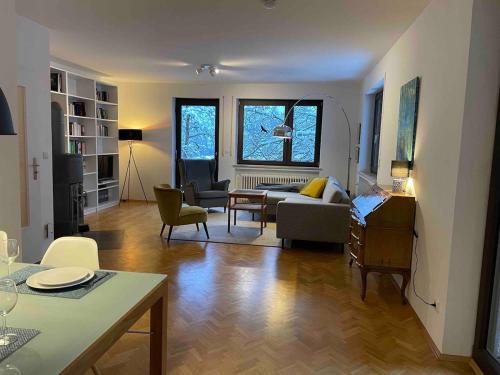 a living room with a couch and a table at Großzügige individuelle Wohnung am Starnberger See in Münsing am Starnberger See