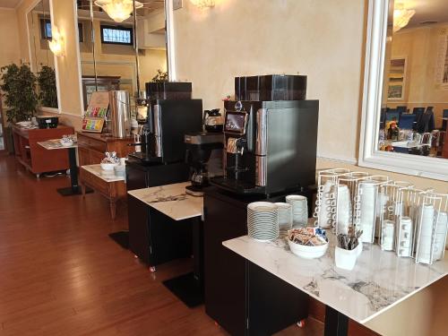a coffee shop with coffee machines on a counter at Hotel Villa Maria in Desenzano del Garda