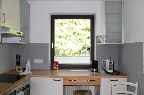 a kitchen with a window in the middle of it at Großzügige individuelle Wohnung am Starnberger See in Münsing am Starnberger See