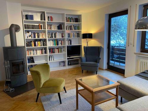 a living room with a book shelf filled with books at Großzügige individuelle Wohnung am Starnberger See in Münsing am Starnberger See