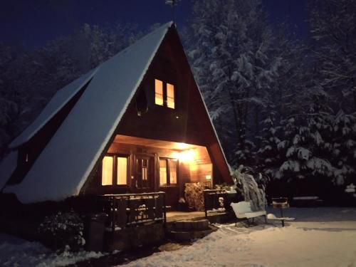 a cabin in the snow at night at Domki pod Skałką in Baligród