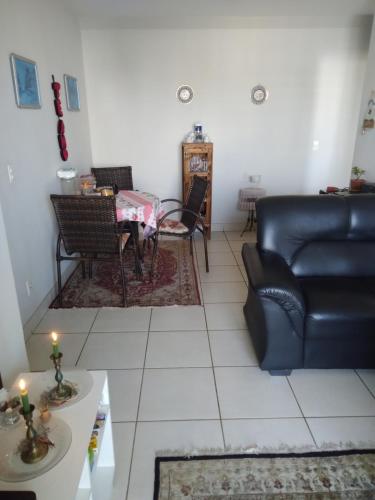 una sala de estar con un sofá y una mesa en Condomínio Gran Felicita Castelo, en Belo Horizonte