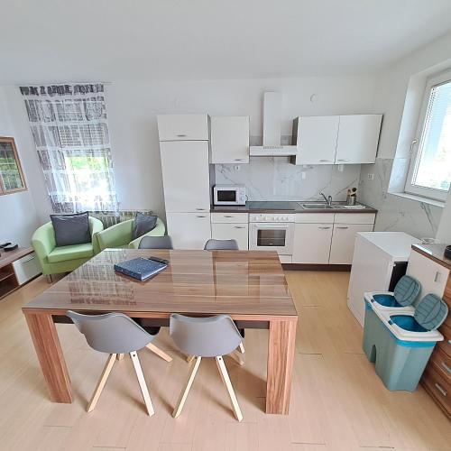 a kitchen with a wooden table and chairs in a room at Apartments Rupnik in Bovec
