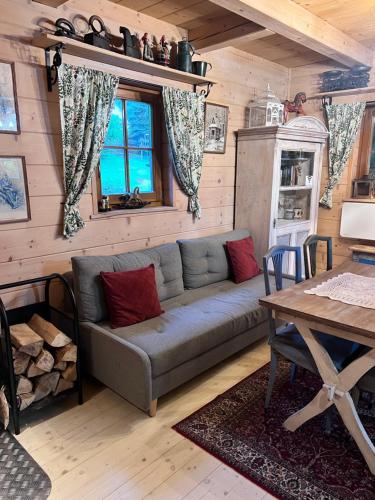 a living room with a couch and a table at Domek pod Jaworami z balią in Sułkowice