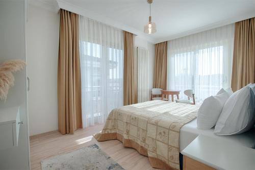 a hotel room with a bed and large windows at Kamer Exclusive Hotel & Suites in Çeşme