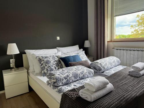 a bedroom with a bed with pillows and a window at Elysian Apartments in Grabovac