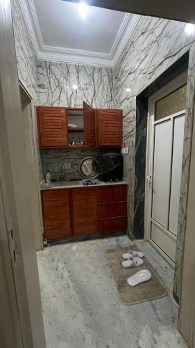 a kitchen with a sink and a stone wall at شقق الخيول البرونزية للشقق المخدومة in Şabyā
