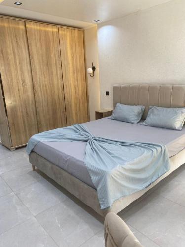 a bedroom with a large bed with blue sheets at Tokyo in Akouda